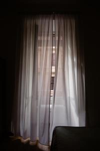 罗马拉基然多拉住宿加早餐酒店的卧室窗户配有白色窗帘和床