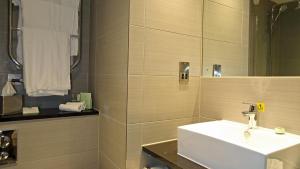 亨廷登亨廷登赛马场假日酒店的浴室设有白色水槽和镜子