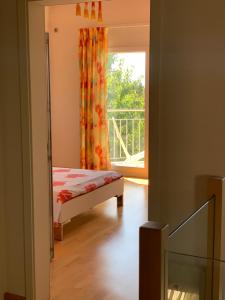 Mont-sur-Rolle威灵托尼亚住宿加早餐旅馆的一间卧室设有一张床和一个阳台的窗户。