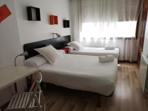 拉科鲁尼亚拉斯瑞尔斯膳食公寓的酒店客房设有两张床和窗户。