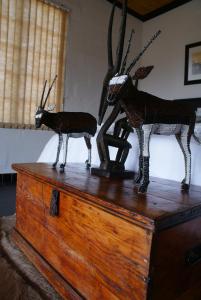 奥茨胡恩Zwartberg View Mountain Lodge的木箱顶上两座驯鹿雕像