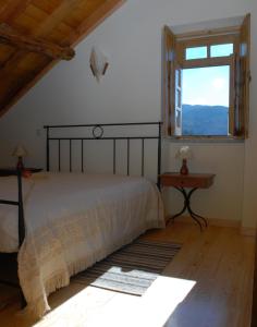 萨布盖鲁Casa da Moreia的一间卧室设有一张大床和一个窗户。