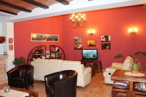 Valdealgorfa萨尔瓦多科拉尔瓦莱罗乡村别墅的客厅设有红色的墙壁和白色的家具