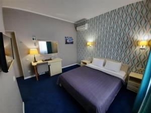 敖德萨Hotel Ajur的一间酒店客房,配有一张床和一台电视