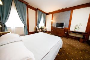 雅西精选酒店的酒店客房设有白色的床和电视。