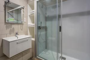 罗伊登罗伊顿海滨乡村酒店的一间带玻璃淋浴和水槽的浴室