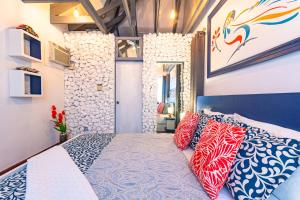 拿骚Parrot Cottage at Viking Hill - Love Beach的一间卧室配有一张带红色和蓝色枕头的床