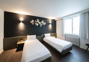 韦弗尔海姆可提纳酒店的酒店客房设有两张床和黑色墙壁。