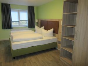 格拉芬道尔施坦格蒂普托普酒店的一间卧室配有一张带白色床单的床和一扇窗户。