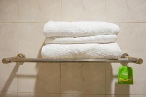 泗水City Residence Kutai 32的浴室毛巾架上的一堆毛巾