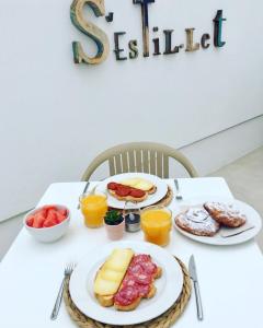 埃斯米洪格兰Hotel S'Estil-let的一张白色桌子,上面放着食物板