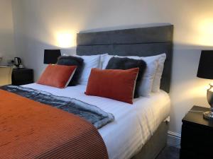 彼得伯勒Black Horse的一间卧室配有一张带橙色和黑色枕头的大床