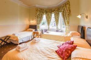 爱丁堡Brae Guest House的带三张床和窗户的客房