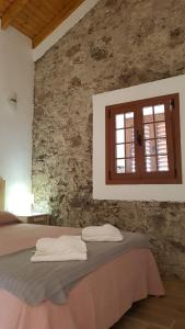埃尔米瓜Apartamento Casa Bibiana 1的一间卧室设有一张床和石墙