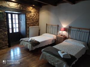特里亚卡斯特拉Albergue Atrio的一间卧室设有两张床和窗户。