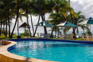 嘎林海斯港艾克波托旅馆的一个带椅子和遮阳伞的游泳池以及大海