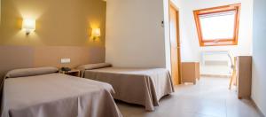 波多诺伏Hotel Duna的客房设有两张床和窗户。