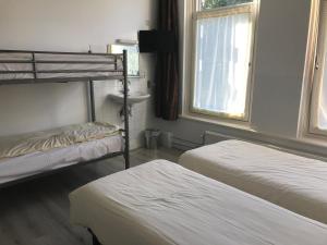 阿姆斯特丹hotel Oosterpark的客房设有两张双层床和盥洗盆。