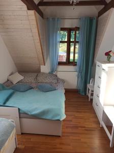 DercMalowniczy Zakątek w Dercu的一间卧室设有一张床和一个窗口
