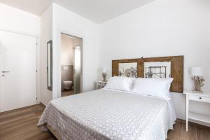 萨维奥迪拉韦纳Ca' Mira - Room&Breakfast的白色卧室配有白色床和木制床头板