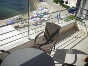 赞吉纳Apartments Kala的阳台配有2把椅子和1张桌子,享有海滩的景致。