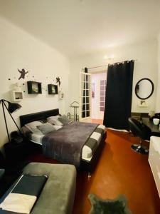 芒通Chambres dans guest house Centre ville的一间卧室配有两张床和一张沙发。