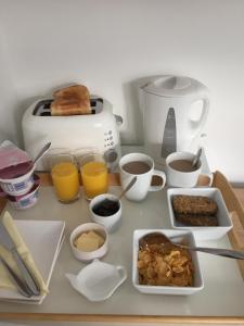 贝辛斯托克Basingstoke En Suite Room in Garden Annex的餐桌上摆放着早餐食品和烤面包机