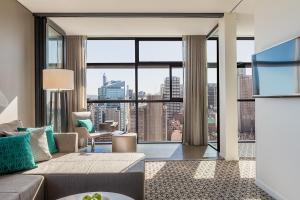 悉尼悉尼辉盛阁国际公寓的带沙发和大窗户的客厅
