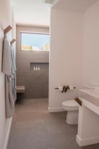 攀瓦海滩The Mooring Resort的白色的浴室设有卫生间和窗户。