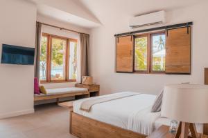 攀瓦海滩The Mooring Resort的一间卧室配有一张床、一张沙发和窗户。