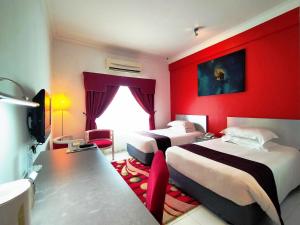 波德申迪克森港口克拉娜海滩度假村的酒店客房设有两张床和红色的墙壁。