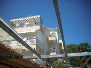 赞吉纳Apartments Kala的带阳台的白色建筑,享有蓝色的天空