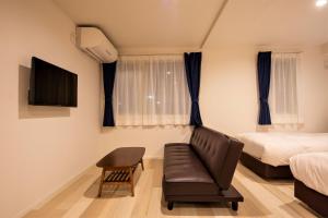 小樽Cozy Inn OTARU的一间带沙发、床和电视的卧室