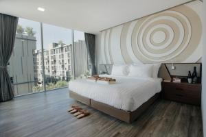 曼谷Olive Bangkok Hotel的一间卧室设有一张大床和一个大窗户