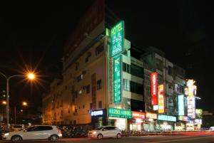 新竹東賓快捷旅店的街道上,夜间有汽车停在建筑物前面
