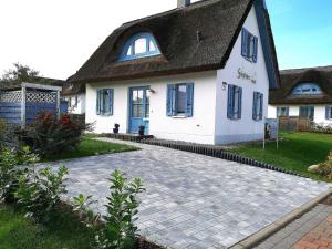 格洛韦Reethaus Stoertebeker ca 100 m zum的白色的房子,有黑色的屋顶和车道