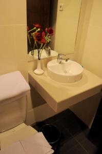 帕卢Amazing Beach Resort Palu的浴室设有水槽和花瓶。