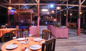 帕卢Amazing Beach Resort Palu的用餐室配有桌椅和灯光