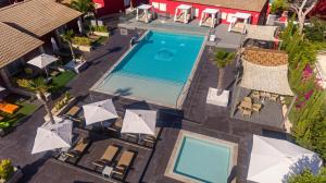 卡拉纳雅达Hotel Paradise Residencial的享有带椅子和遮阳伞的游泳池的上方景色