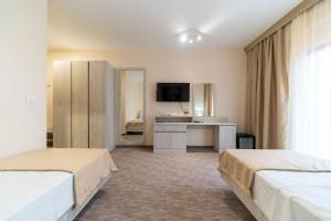 波德戈里察Hotel RIO VERDE的酒店客房配有两张床和一张书桌