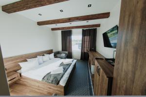 索洛钦Saliuk Lodge的一间卧室配有一张大床和电视