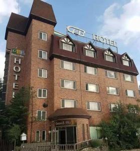 平昌绿色与蓝色汽车旅馆的一座大型砖砌建筑,上面有酒店标志