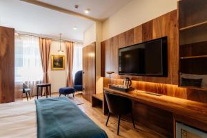 多布尔纳Boutique Hotel Dobrna - Terme Dobrna的配有一张床和一台平面电视的酒店客房