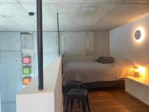 新乌尔姆Soulfactory Apartments的一间卧室配有床、桌子和凳子