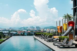吉隆坡ExpressionZ KLCC By Starwood Luxury的一座带躺椅的建筑的顶部游泳池