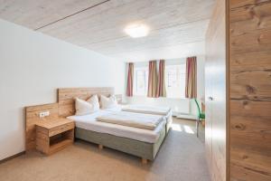 费尔德基希Motel Engel - self checkin的一间卧室设有一张床和木墙