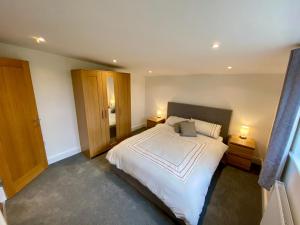 Sutton ValenceBlackberry Cottage的卧室配有一张白色大床和两盏灯。