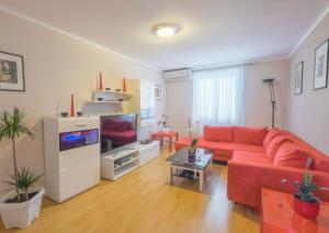佩罗杰Apartman Andja sea and garden view的客厅配有红色沙发和电视