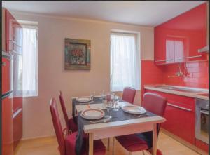 佩罗杰Apartman Andja sea and garden view的厨房配有桌椅和红色墙壁