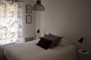 波尔多Burdigala Homes - Appart de Lalande的卧室配有带枕头的白色床和窗户。